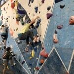Uczniowie klasy 5 podczas wspinaczki na ściance boulderowej.