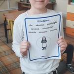 Dziewczynka trzyma kartę z wypisanymi cechami tytułowej bohaterki 