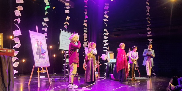 Uczniowie w kostiumach teatralnych na scenie Opery.