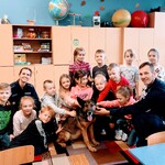 Uczniowie klasy Ia pozują z policjantami i psem do zdjęcia.