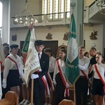 Poczty sztandarowy ustawione w środku kościoła w trakcie liturgii.