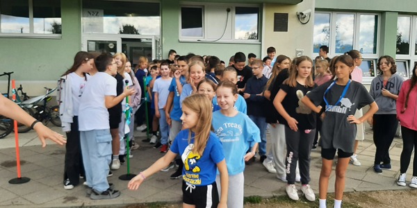 Klasy przygotowują się do Sztafety Przyjaźni przed wejściem głównym szkoły.