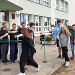 Klasa siódma kończąca bieg w sztafecie przyjaźni przebija piątki klasie starszej.