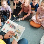 Bibliotekarz czyta dzieciom książkę.