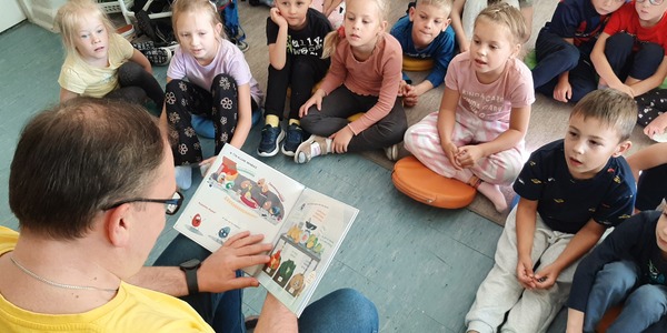 Bibliotekarz czyta dzieciom książkę.