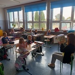 Bibliotekarka prezentuje uczniom kl. I a ilustracje z książki.