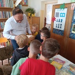 Bibliotekarz pokazuje dzieciom karty katalogowe.