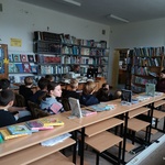 Bibliotekarka czyta uczniom opowiadanie biblioterapeutyczne.