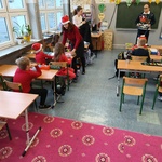 Bibliotekarka wręcza dzieciom książki.