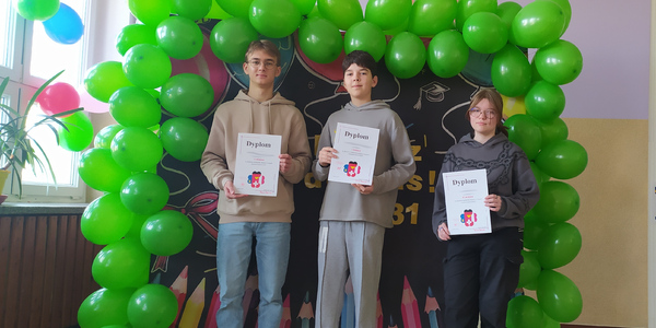 Uczniowie na tle girlandy z zielonych balonów
