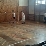 Uczniowie klasy 4 w sali gimnastycznej grają w turnieju unihokeja.