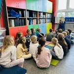 Klasa Ib słucha książki czytanej przez nauczyciela w Dniu Głośnego Czytania