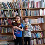 Uczniowie z misiami w bibliotece