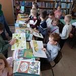 uczniowie z kl.I b oglądają ksiązki o misiach w bibliotece